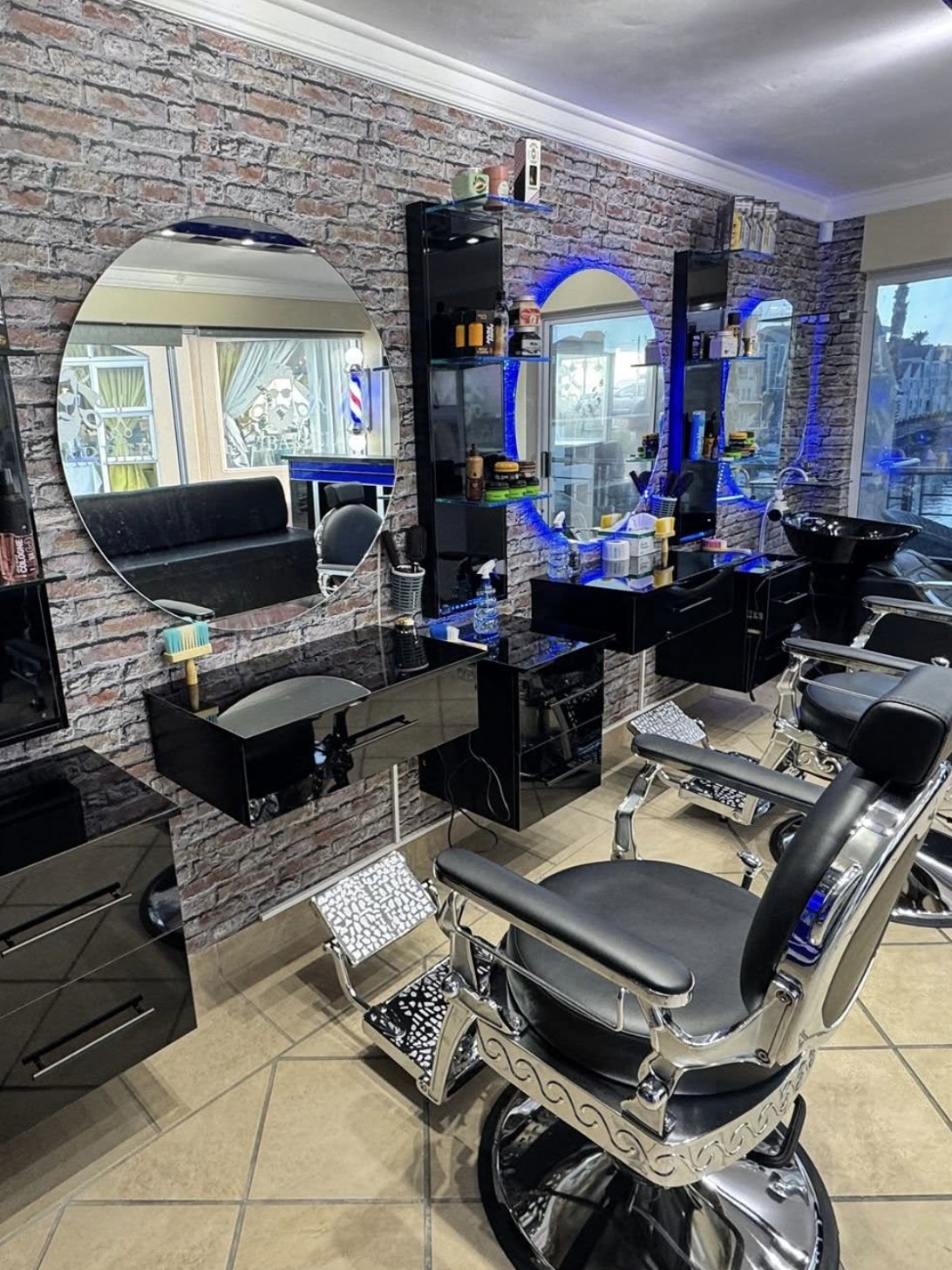 Bay Barber interior: chrome vintage chair, gloss black stations, exposed brick.